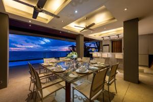 a dining room with a table and a view of the ocean at The View in Taling Ngam Beach
