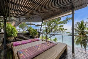 a bed on a deck with a view of the ocean at The View in Taling Ngam Beach
