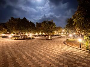 a park at night with trees and lights at Vantara Gir Resort in Sasan Gir