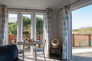 a living room with a table and a sliding glass door at 4 Meadow View in Woolacombe