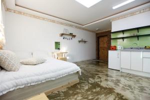 a bedroom with a large bed and a kitchen at Danyang paramaeul in Danyang