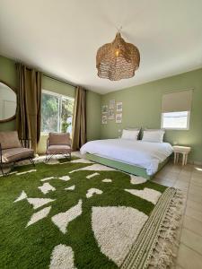 a bedroom with a large bed and a green at Villa TerraVerde in Al Ghar