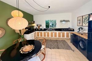a room with a table and a kitchen with green walls at Villa TerraVerde in Al Ghar