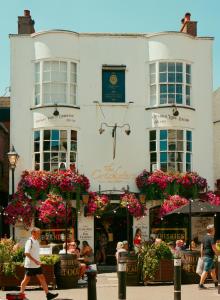 a white building with flowers in front of it at West Hill Apartment in Brighton & Hove