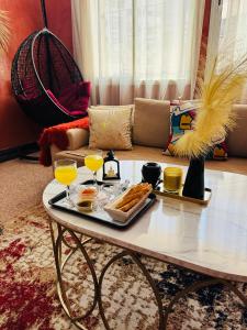 a coffee table with a tray of food and two glasses of orange juice at Le belvédère in Casablanca