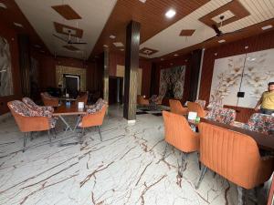 a lobby with tables and chairs in a restaurant at Rajstar Resort in Murthal