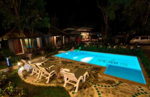 a swimming pool at night with two lawn chairs next to it at The Sylvana Pai in Pai