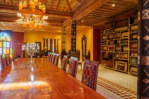 a dining room with a long wooden table and chairs at Hotel Riad Xaluca in Merzouga +272 photos