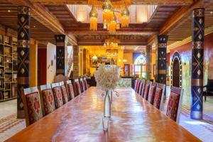 a long wooden table in a room with chairs at Hotel Riad Xaluca in Merzouga