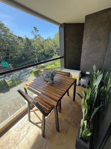 a room with a wooden table and a large window at Hotel Rioverde Loft cerca De Aeropuerto Jmc in Rionegro