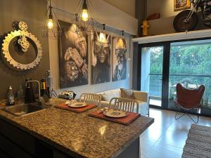 a kitchen with a counter with a sink and a table at Hotel Rioverde Loft cerca De Aeropuerto Jmc in Rionegro