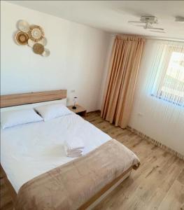 a bedroom with a large bed and a window at Deltaville in Mahmudia