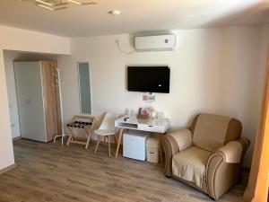 a living room with a couch and a table and a tv at Deltaville in Mahmudia