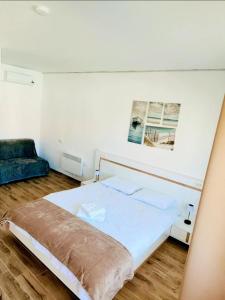a bedroom with a large white bed and a couch at Deltaville in Mahmudia