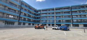 a large apartment building with cars parked in a parking lot at Garsoniera Daria in Saturn