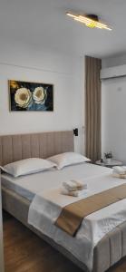 a bedroom with a large bed with white sheets at Garsoniera Daria in Saturn
