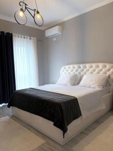 a bedroom with a large bed with a black blanket at Vila 007 in Velipojë