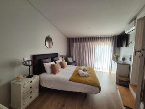 a bedroom with a large bed with two stuffed animals on it at Casa da Padaria in Folgosa +92 photos