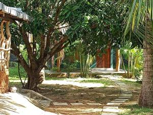 a garden with a palm tree and a building at Tropical Lodge Yala in Kirinda