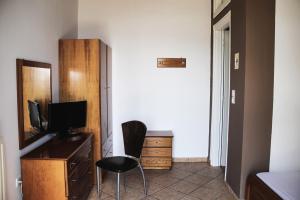 Zimmer mit einem Schreibtisch, einem Stuhl und einer Kommode in der Unterkunft Guesthouse Vrenthi in Karitena