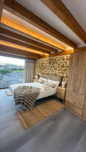 a bedroom with a bed and a stone wall at Casona de Queveda in Queveda