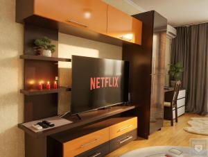 a living room with a television on a entertainment center at RentHouse Apartments Metropolis in Chişinău