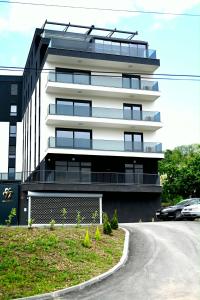a tall building with a car parked in front of it at Orhideja 075 in Tuzla