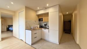 a kitchen with white cabinets and a counter top at Noclegi Słodki Sen 2 in Lublin