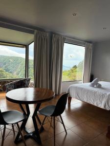 a bedroom with a bed and a table and chairs at Rainbow Valley Lodge Costa Rica in Monteverde Costa Rica