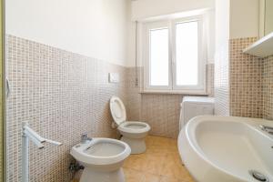 a bathroom with a toilet and a tub and a sink at Bambinopoli Al Mare in Alba Adriatica +29 photos