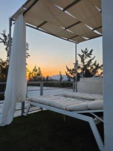 a bed under a white canopy on a patio at Pelekanos Apartment in Kamilari