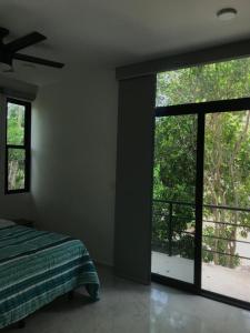 a bedroom with a bed and sliding glass doors at Casa Maya in Puerto Morelos +21 photos