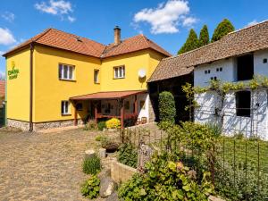 a yellow house with a fence in front of it at Kovárna Klapý pod Hazmburkem - České středohoří in Klapý