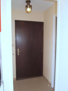 a brown door in a room with a tile floor at Appartement Soleil d'Oc 5 in Cazaubon