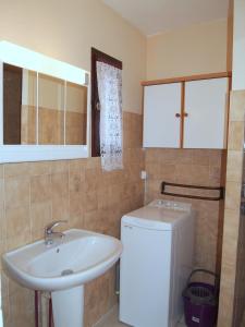 a bathroom with a sink and a washing machine at Appartement Soleil d'Oc 5 in Cazaubon