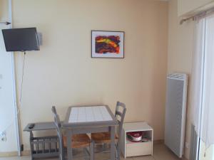 a table and chairs in a room with a picture on the wall at Appartement Soleil d'Oc 5 in Cazaubon +2 photos