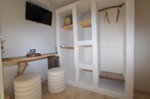 a room with white walls and a tv and stools at Villa rundinella in Vero