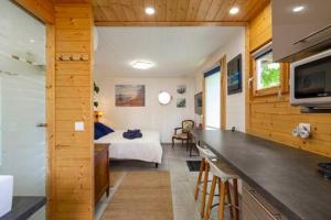 a room with a bedroom with a bed and a kitchen at Tiny House de Charme & Oasis Privée in Toulouse