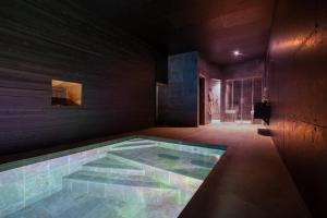 a swimming pool in a room with a table at SUITE TESORO climatisée avec piscine spa hammam et jardin avec piscine in Saint-Martial-sur-Né