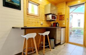 a kitchen with two stools at a counter with a microwave at Tiny House de Charme & Oasis Privée in Toulouse +5 photos