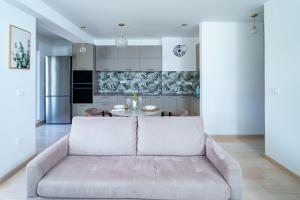 a living room with a couch and a kitchen at Apartments with Pool 5 Min Walk to Beach in Igalo