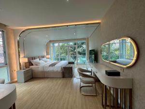 a bedroom with a bed and a desk and a mirror at IP on HOME 1 in Jomtien Beach +62 photos
