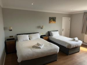 two beds in a hotel room with towels on them at Staindrop Hotel in Sheffield +99 photos