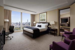 a hotel room with a bed and a desk with a computer at Mandarin Oriental, New York in New York