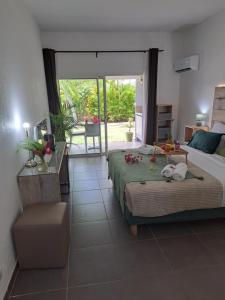 a bedroom with a bed and a table with flowers on it at Ti Pipirit in Saint-François +12 photos