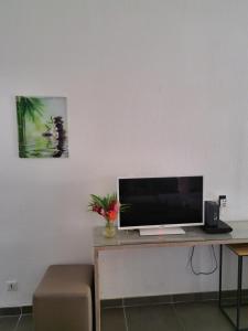 a desk with a computer monitor on top of it at Ti Pipirit in Saint-François