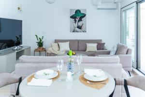 a living room with a white table and a couch at Apartments with Pool 5 Min Walk to Beach in Igalo