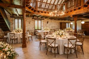 a large room with tables and chairs with flowers at Chateau Eyparsac in Beyssac +98 photos
