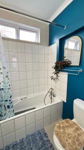 a bathroom with a bath tub and a toilet at The Muizenberg Muse in Muizenberg +10 photos