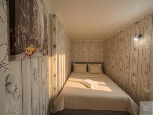 a small bedroom with a bed with two towels on it at RentHouse Apartments Metropolis in Chişinău